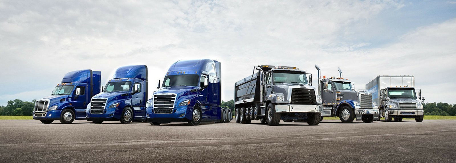 Medium and heavy duty trucks lined up outside the shop